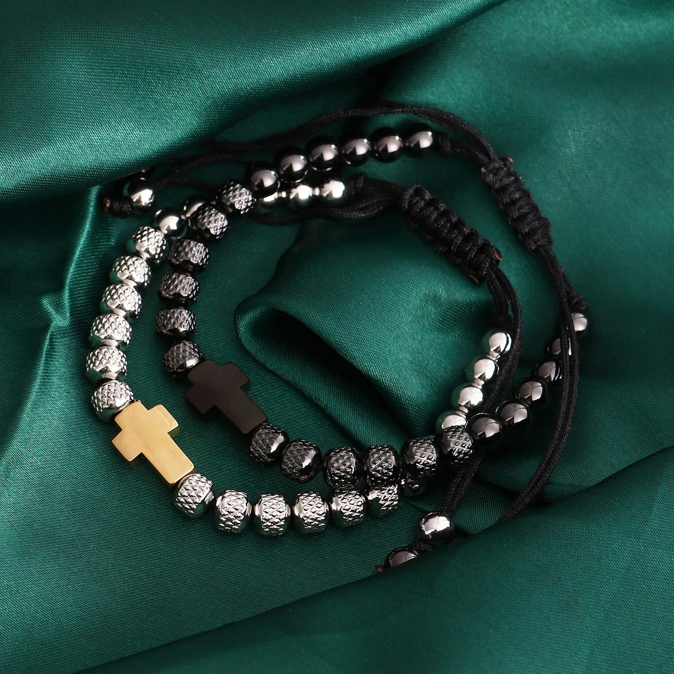 Bracelet with beads and cross charms on a green fabric background