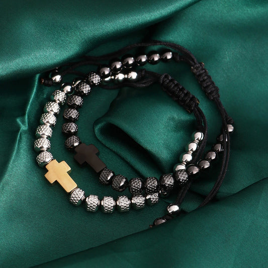 Bracelet with beads and cross charms on a green fabric background